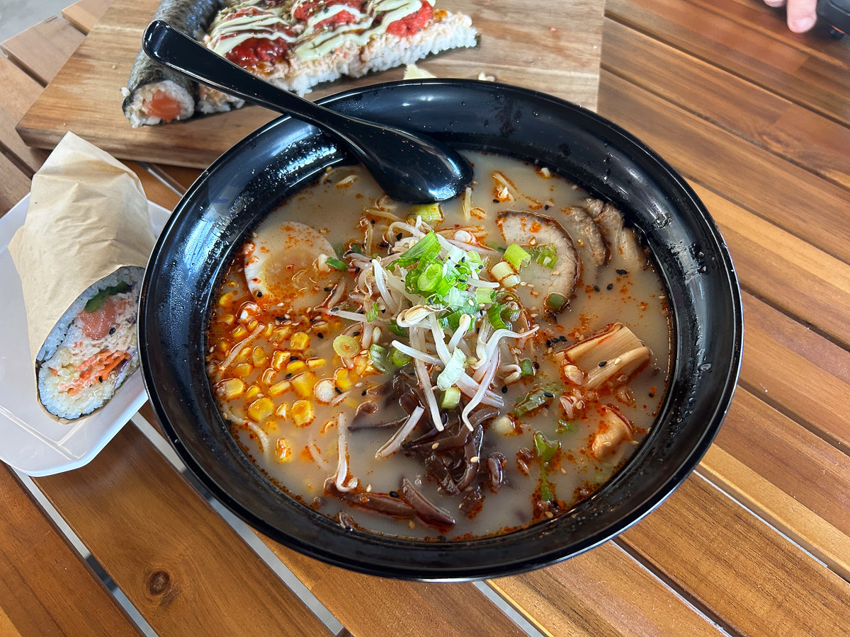 ramen with toppings in a black bowl on a wooden table